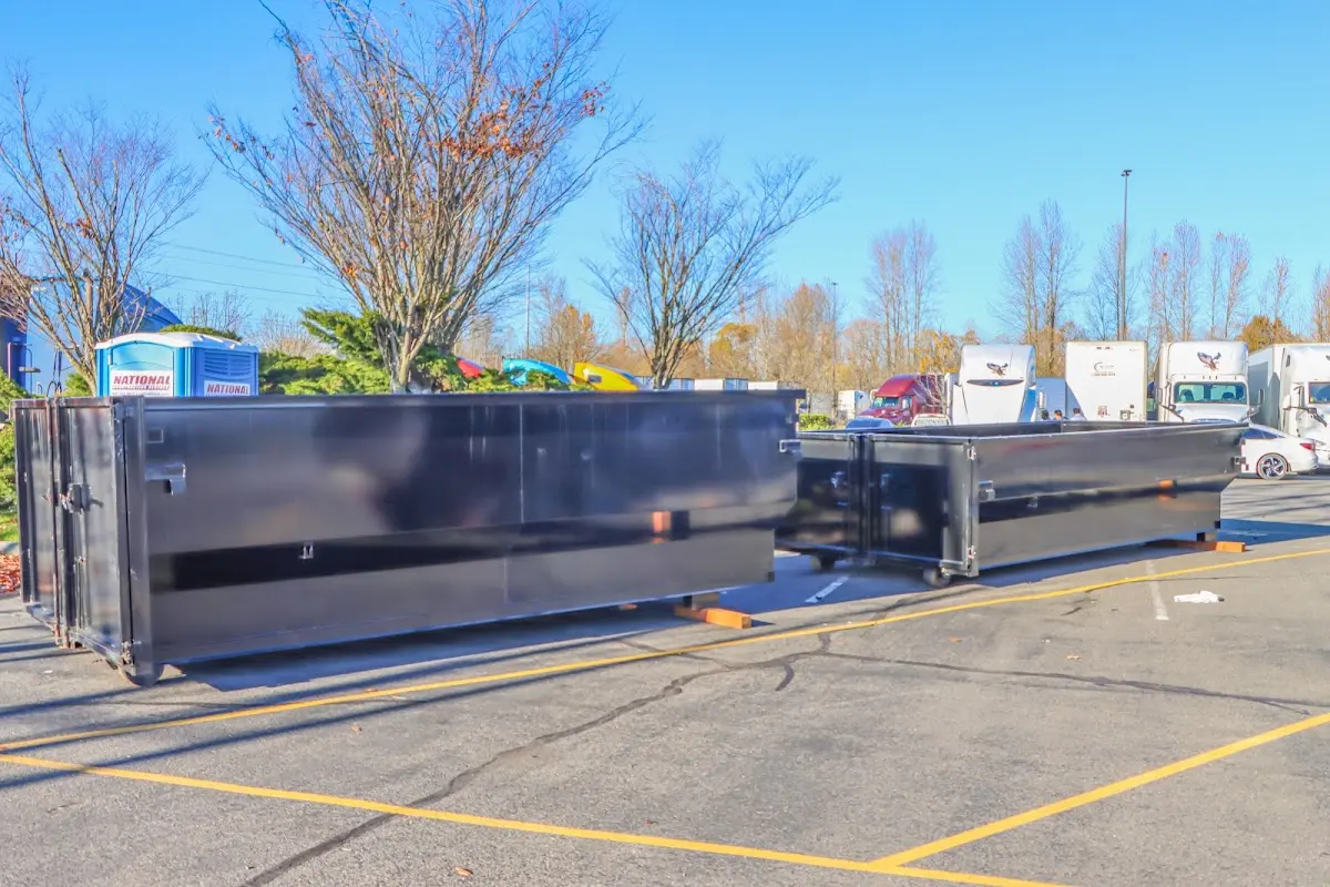 Professional dumpster rental service with roll-off container on residential driveway in Alpine